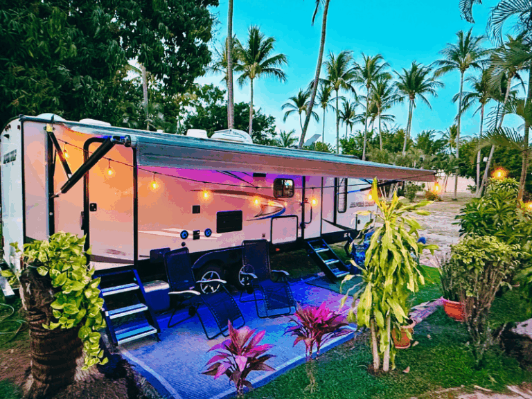 Outdoor dining area at camper rental in Puerto Vallarta with bar fridge and tropical garden setting